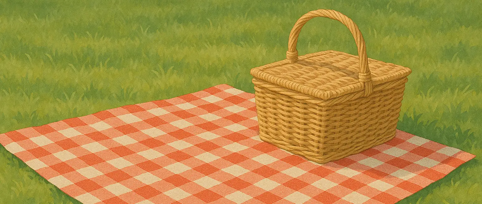 A picnic basket on a blanket in a park